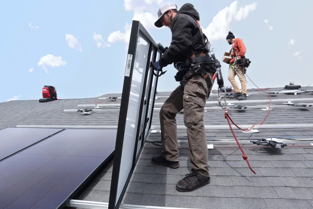 Installers on Roof Placing a Solar Panel.png