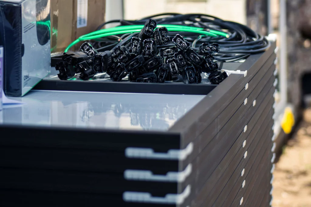 Solar-Panels-Stacked-with-Other-Equipment-Preparing-for-Install stack of different solar panels options and other necessary equipment required for rooftop solar installation