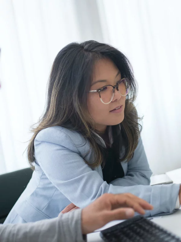 One male and one female, coworkers, evaluating data on a computer monitor