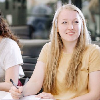 Two female Blue Raven Solar employees, sitting in a conference room