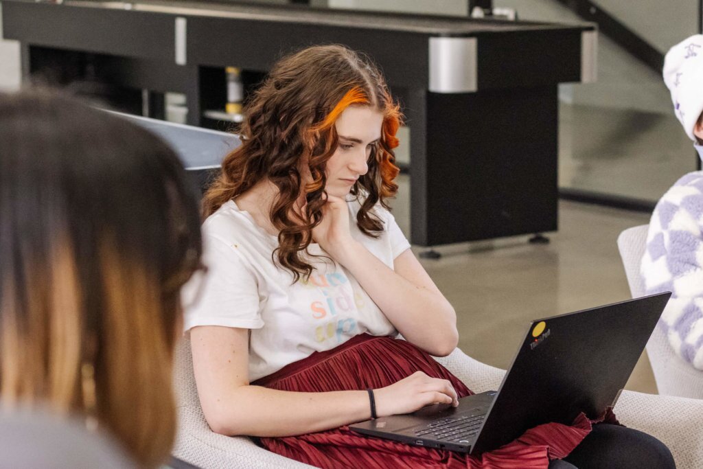 Female Blue Raven Solar employee working on a laptop while sitting