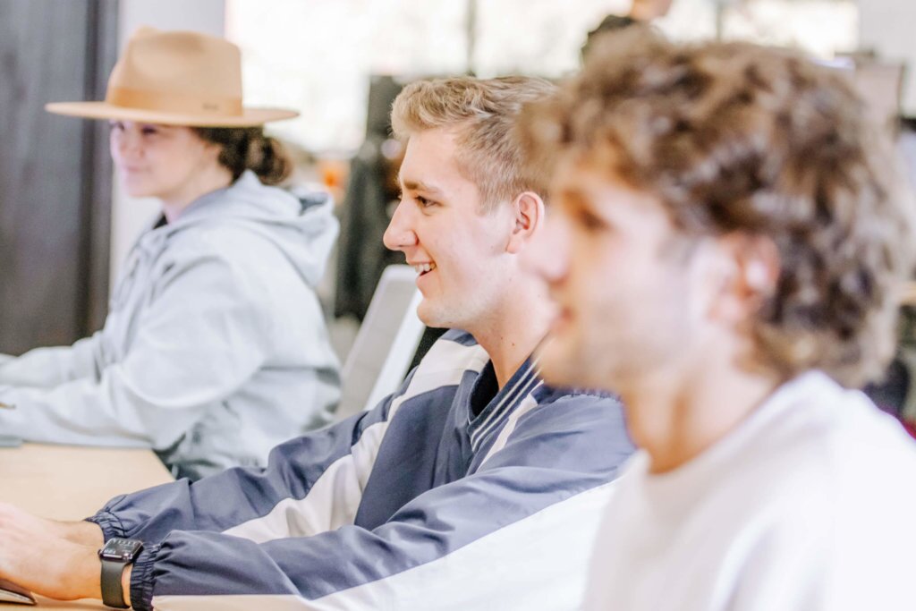 Three Blue Raven Solar employees sitting at their desks, working on computer monitors in a row