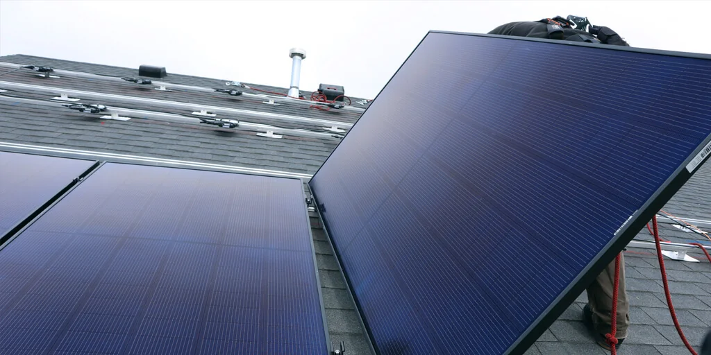 Solar panel installer, installing solar panels on roof of home