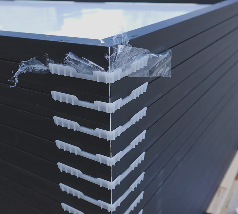 Up close view of solar panels stacked on top of each other on a wood pallet