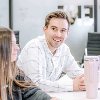 Two Blue Raven Solar employees, a female and male, in a large conference room