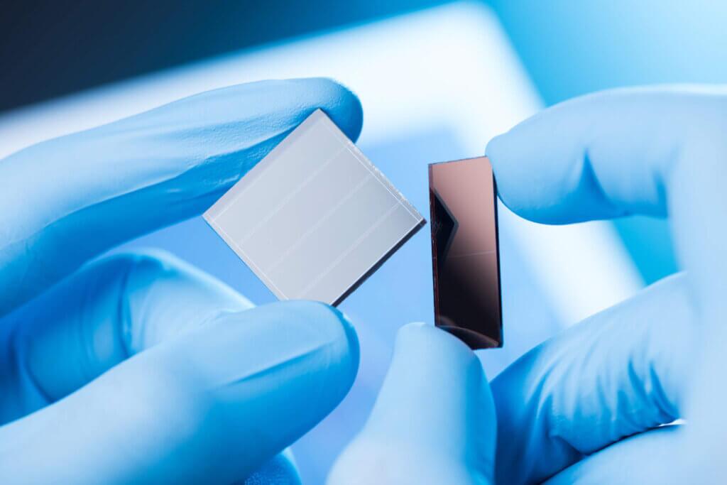 Small components held between fingers in blue, latex gloves