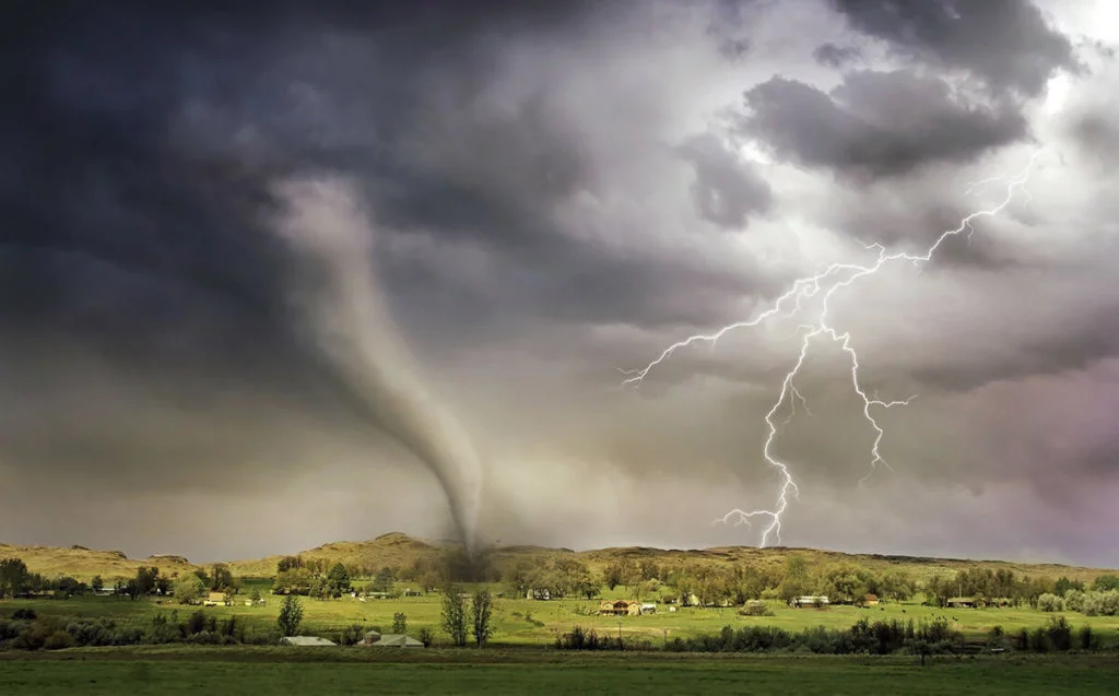 Storm-Happening Dark clouds, tornado, and lightening striking a green hill scattered with houses and trees