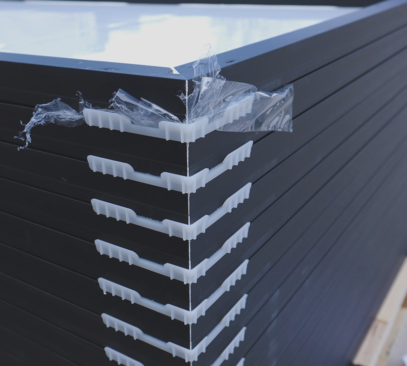 Up close view of solar panels stacked on top of each other on a wood pallet