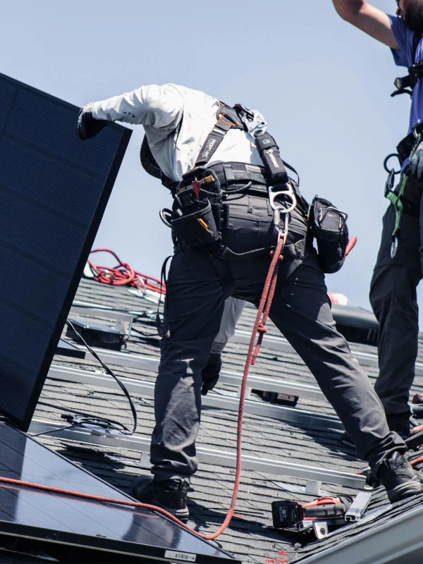 Two Blue Raven Solar installers laying out panels and connecting them to the racking system