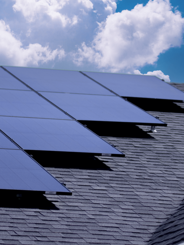 Multiple monocrystalline solar panels installed on a roof with bright clouds in the background. Best Residential Solar Panels.