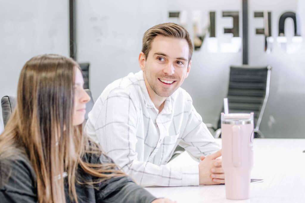 Two Blue Raven Solar employees, a female and male, in a large conference room