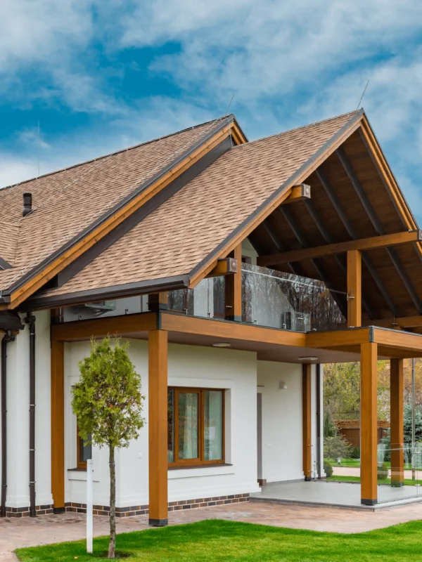 White, single-level house with exposed beams and high pitched roof line