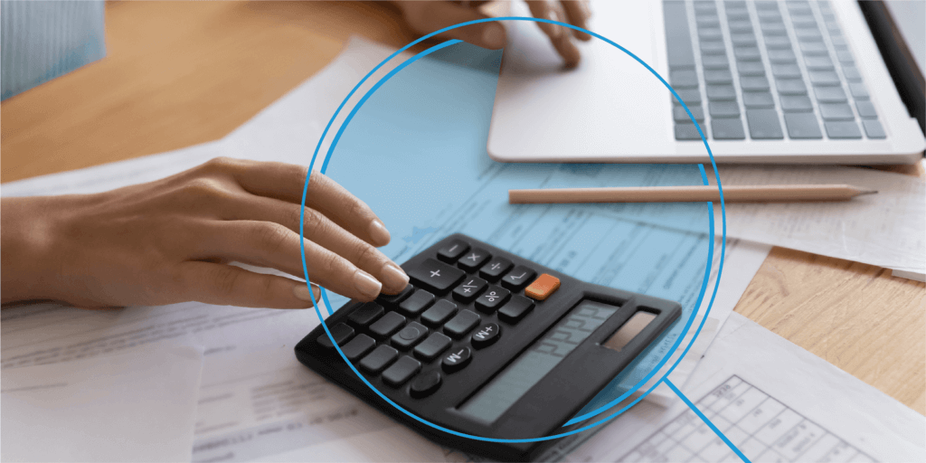 How the Solar Investment Tax Credit Works-04 Individual working on a black calculator, sitting on top of paperwork, and laptop