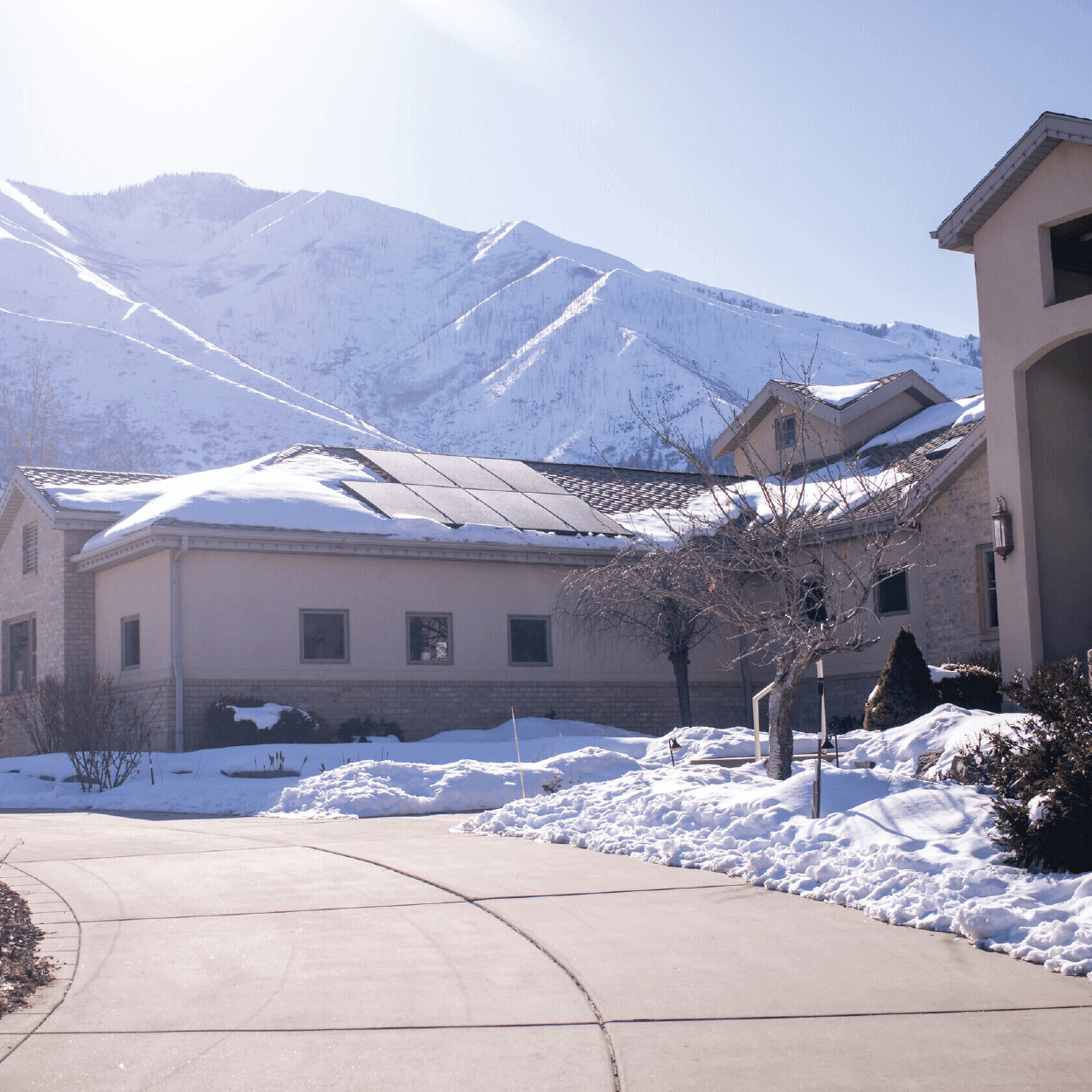 Large building structure with solar panel system installed with snow-covered mountain in the background