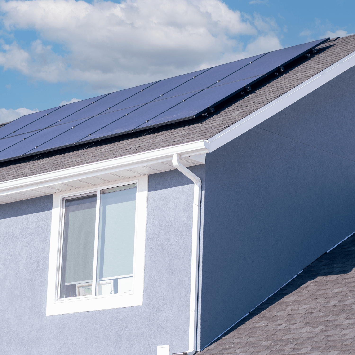 12-panel solar installation on a pale blue stucco house