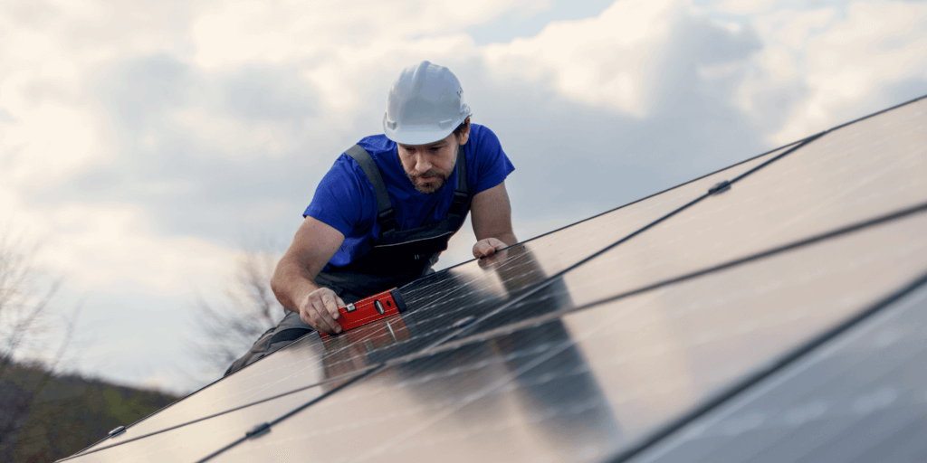 Are Black and Blue the Only Solar Panel Color Options-03 Solar panel installer in a blue t-shirt with a white hard hat inspecting rooftop solar panel installation