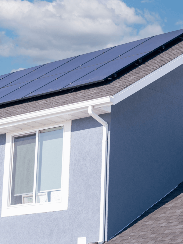 12-panel solar installation on a pale blue stucco house