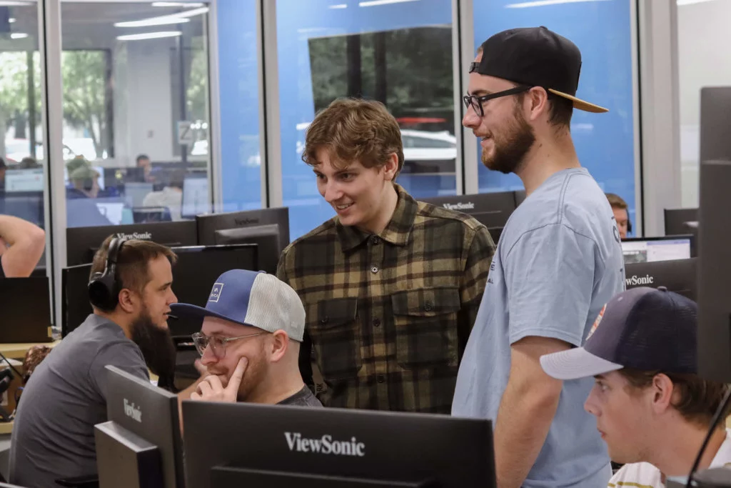 Group-of-Blue-Raven-Solar-Employees Group of Blue Raven Solar employees, standing and sitting around a computer monitor