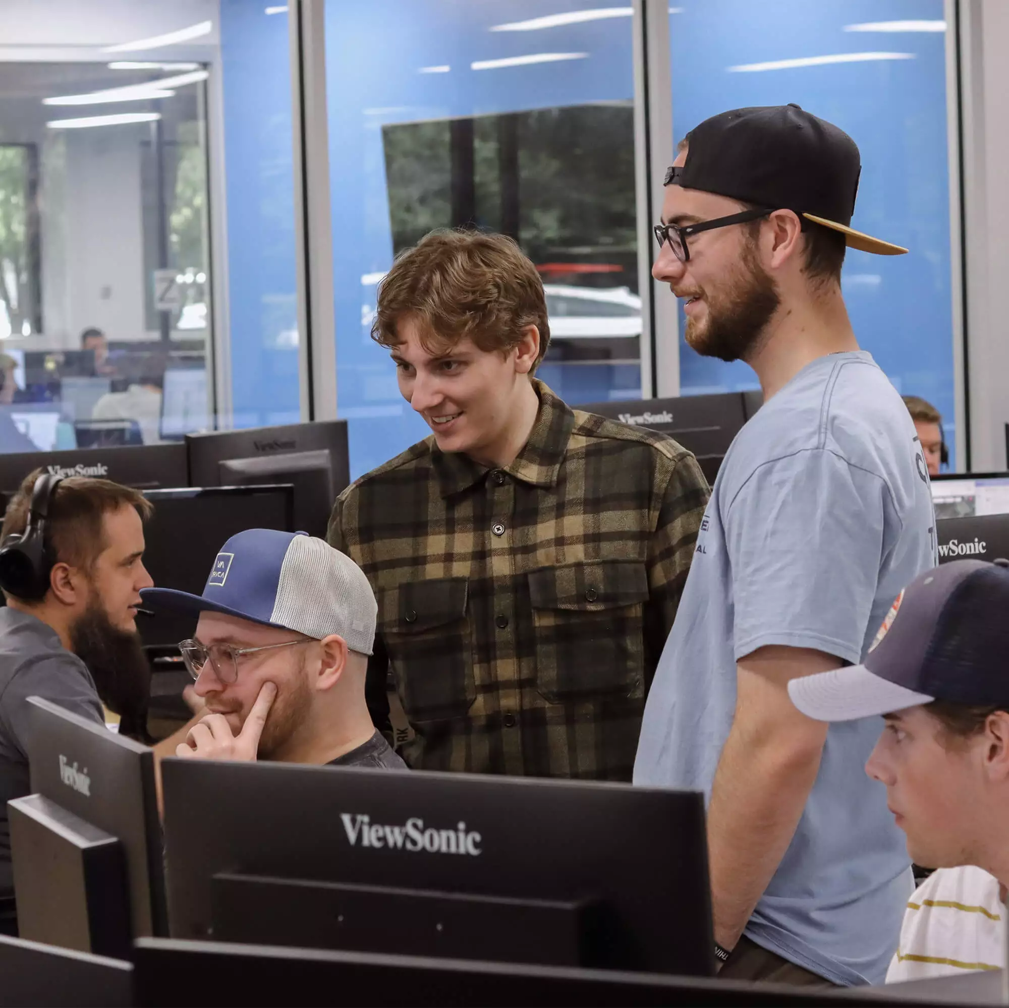 Group of Blue Raven Solar employees, standing and sitting around a computer monitor