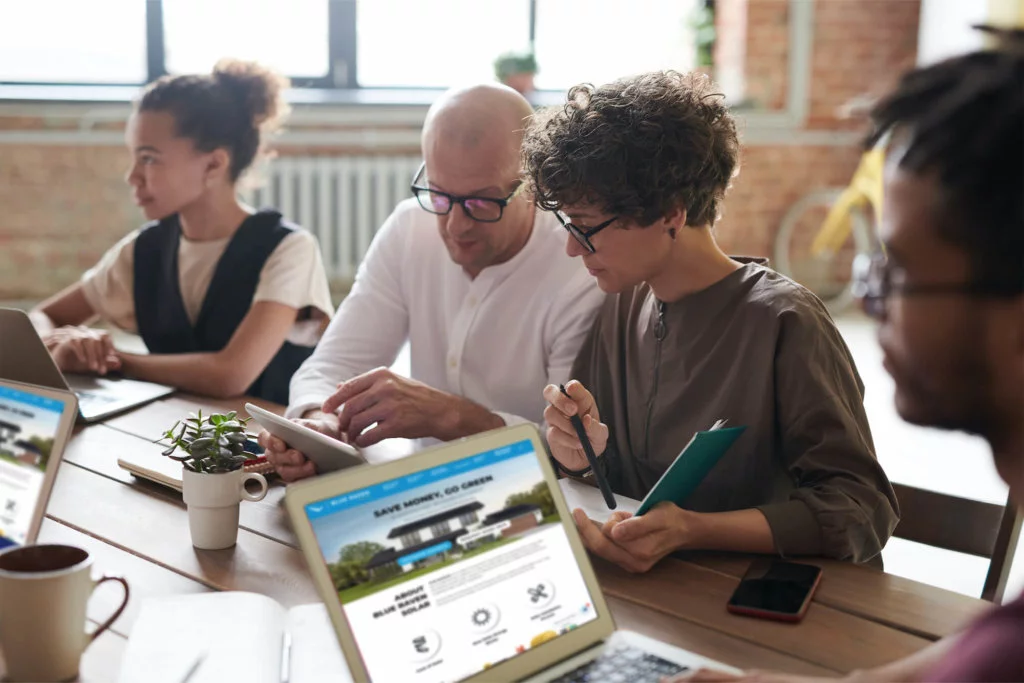 Four employees working together during a meeting at a large conference table