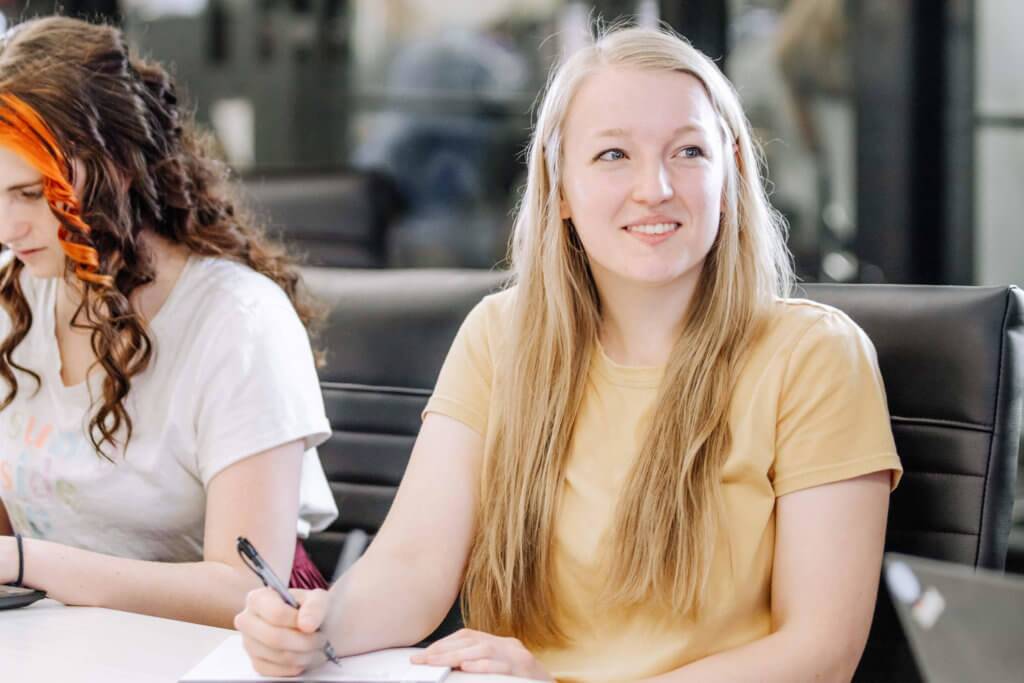 Two female Blue Raven Solar employees, sitting in a conference room