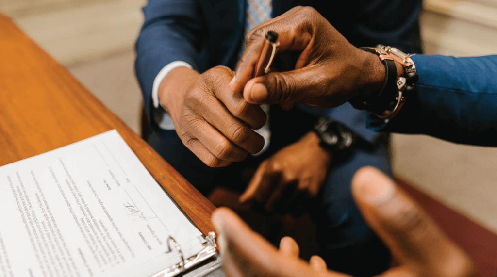 Are Solar Panels Worth It-06 Two males in suits preparing to sign an agreement, handing off the pen