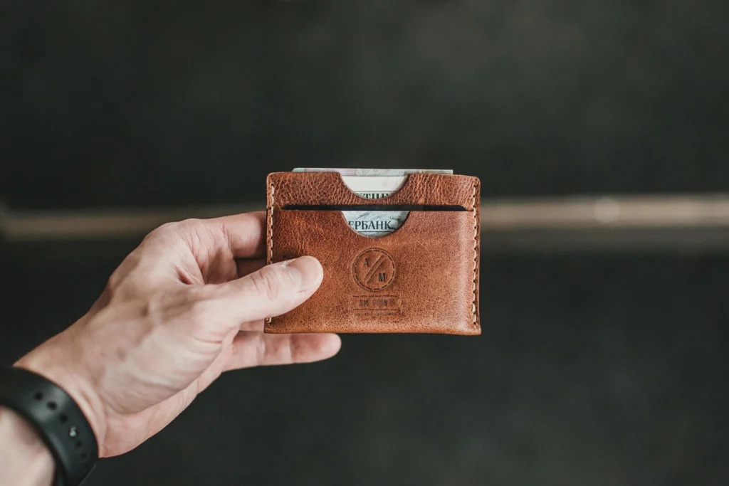 Wallet Male holding a brown leather wallet with cash and ID