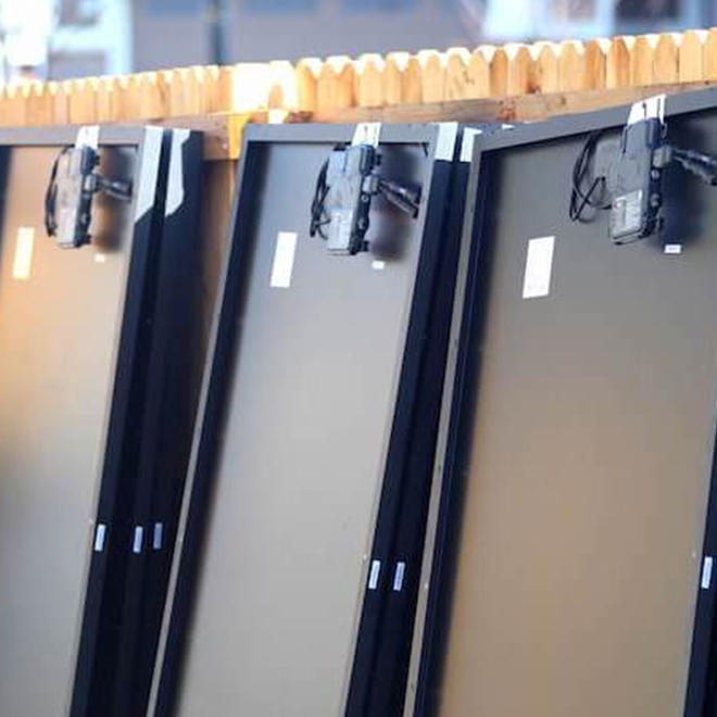 Back-of-Solar-Panels Back of solar panels, lined up against a wood fence