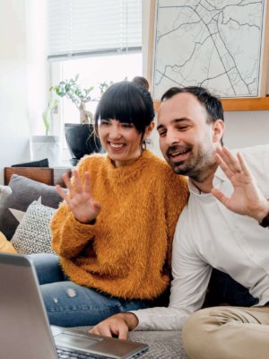 Couple-smiling-and-waving happy couple maximizing savings with solar