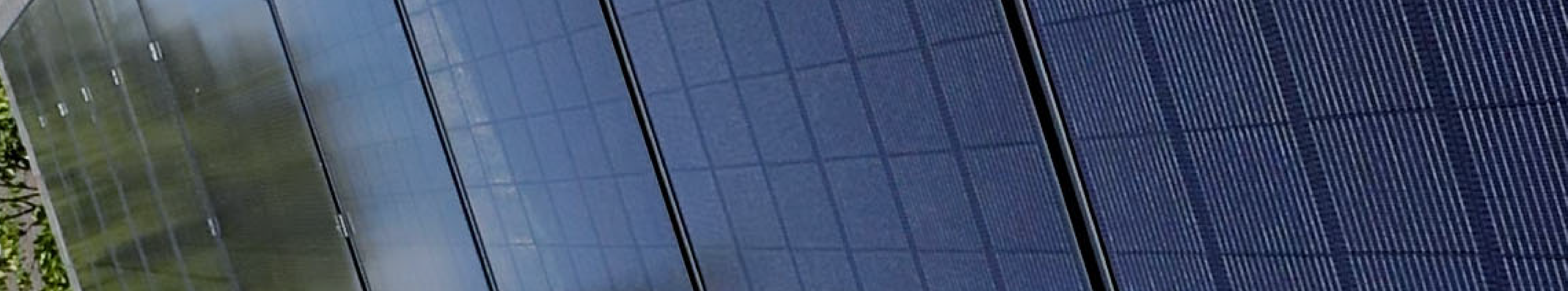 Up close preview of solar panels installed in a row and the reflection on the left hand side