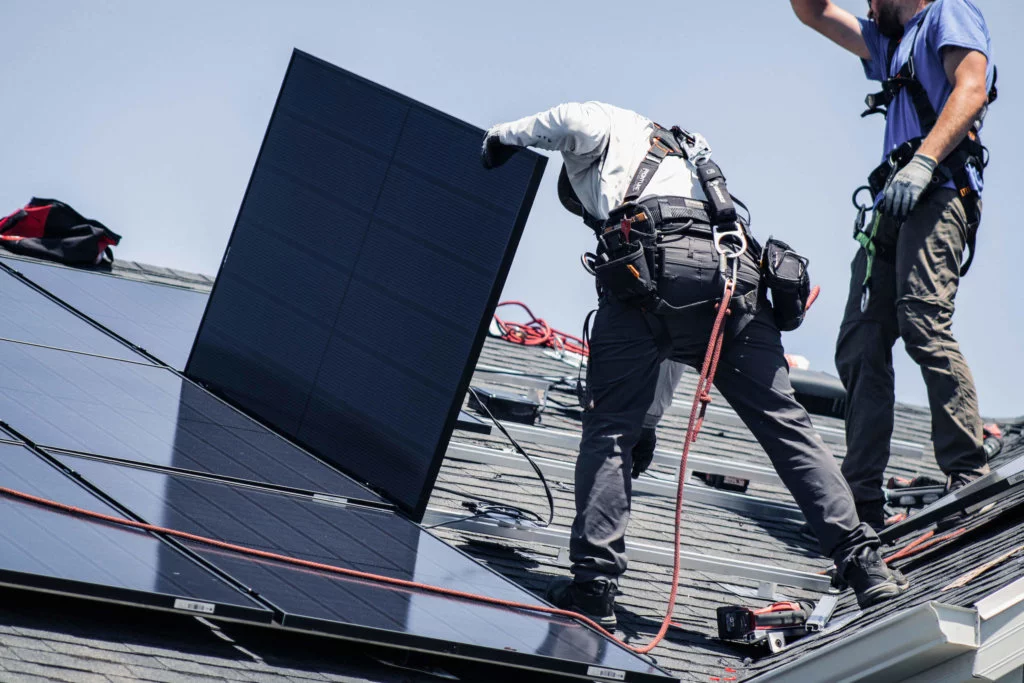 Two Blue Raven Solar installers laying out panels and connecting them to the racking system