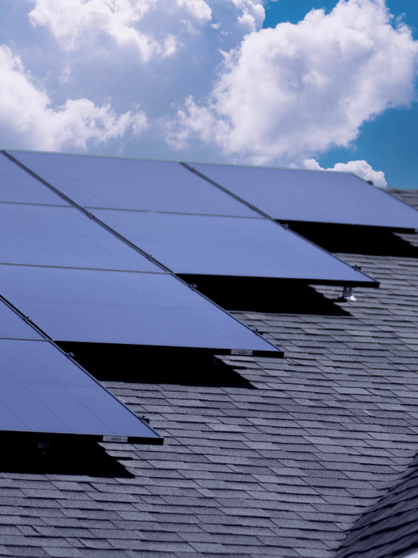 Multiple monocrystalline solar panels installed on a roof with bright clouds in the background. Best Residential Solar Panels.