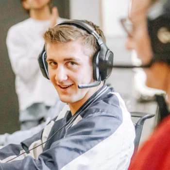 Male Blue Raven Solar employee talking to a customer through a headset while sitting at his desk