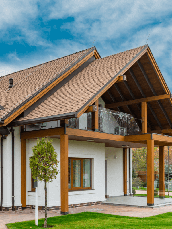 White, single-level house with exposed beams and high pitched roof line