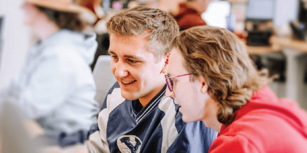 Unveiling the Renewable Energy Industry-01 Two young males, looking at a computer screen in a corporate setting