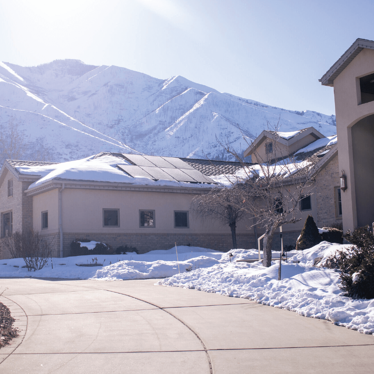 Large building structure with solar panel system installed with snow-covered mountain in the background