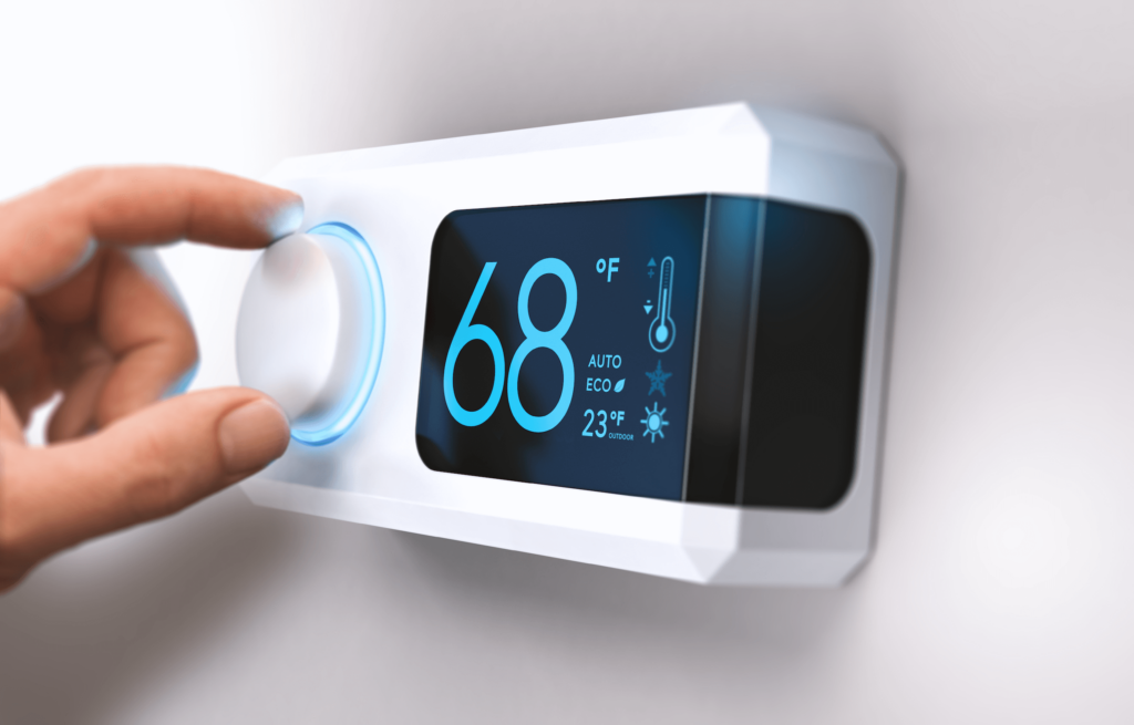 Essential Winter Energy Saving Tips-01 Smart thermostat featuring 68 degrees installed on white wall and a hand adjusting the knob