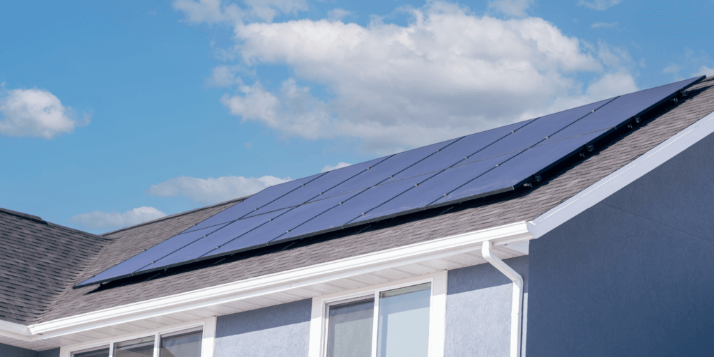 12-panel solar installation on a pale blue stucco house