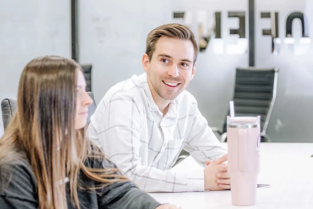 Two Blue Raven Solar employees, a female and male, in a large conference room