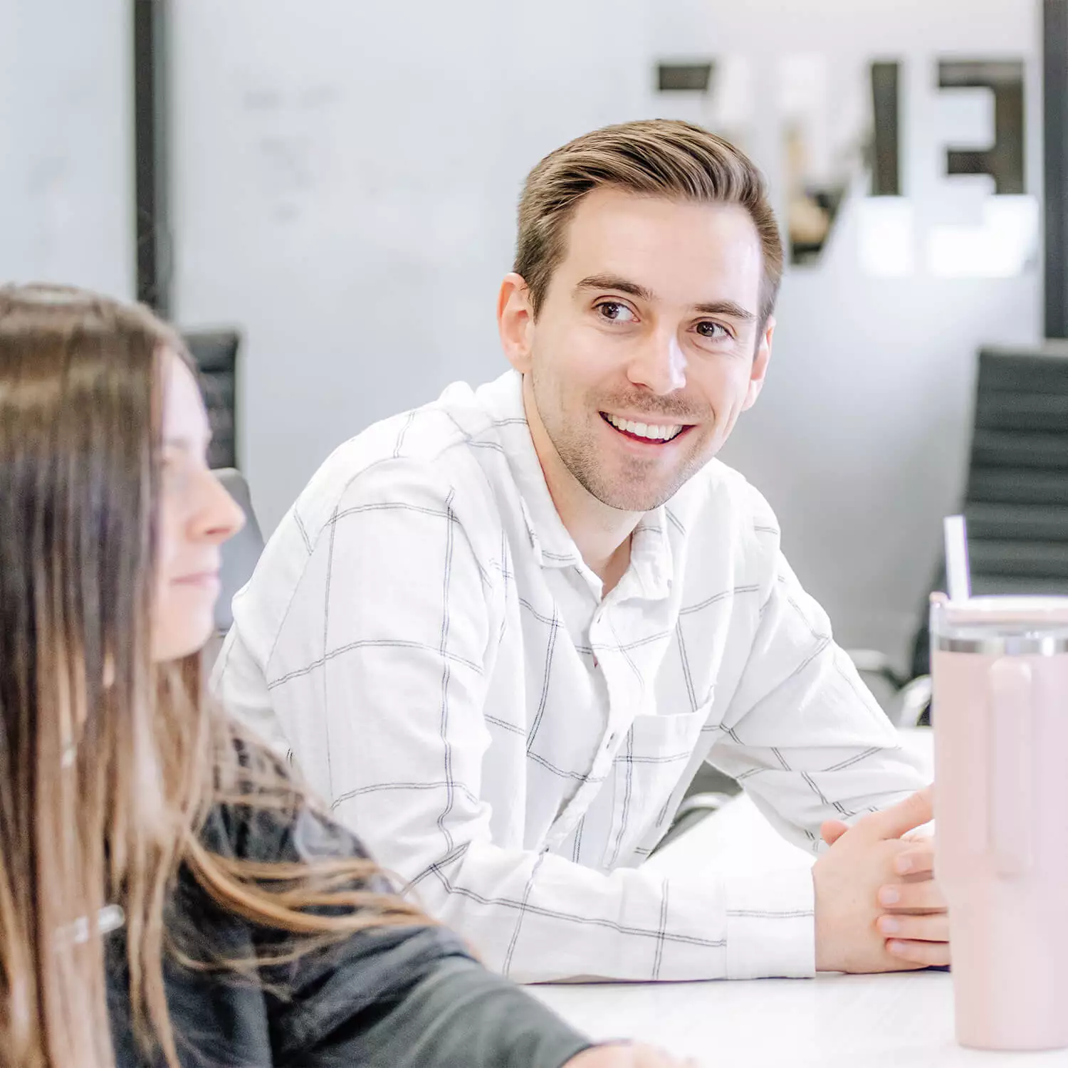 Two Blue Raven Solar employees, a female and male, in a large conference room